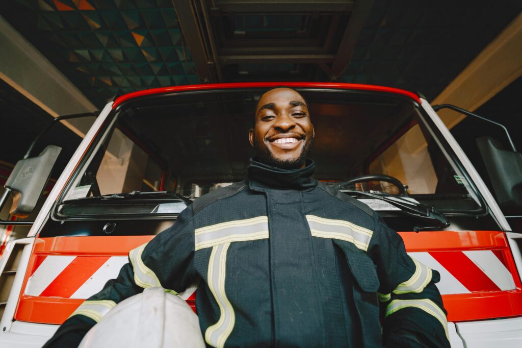 A Man Standing Near Fire Truck Smiling at the Camera